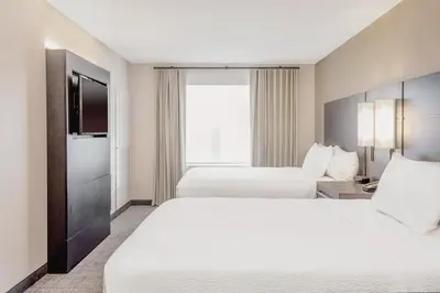 a hotel room with two beds and a television at Residence Inn by Marriott Loma Linda Redlands in Redlands