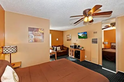 a hotel room with a bed and a living room at Robinhood Resort in Big Bear Lake