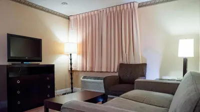 a living room with a couch and a television in a hotel room at Studio 6 Anaheim Hills CA in Anaheim