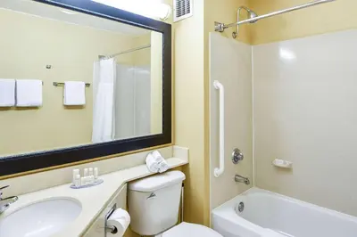a bathroom with a sink and a toilet and a mirror at SureStay Hotel by Best Western Ontario Airport in Ontario