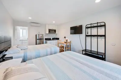 a hotel room with two beds and a kitchen at Unik Motel in Harbor City