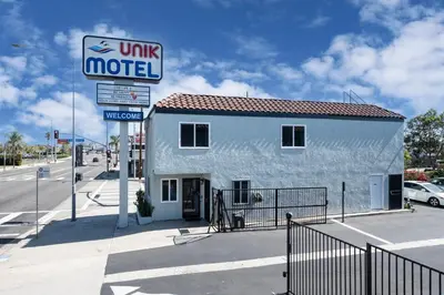 a building with a sign in front of a motel at Unik Motel in Harbor City