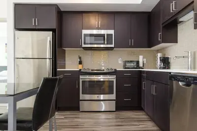 a kitchen with stainless steel appliances and wooden cabinets at Luxury Highrise Living Downtown LA in Los Angeles