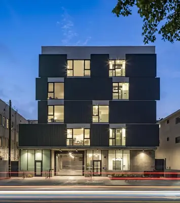 an office building with a black facade at night at The Metric - Los Angeles Downtown in Los Angeles