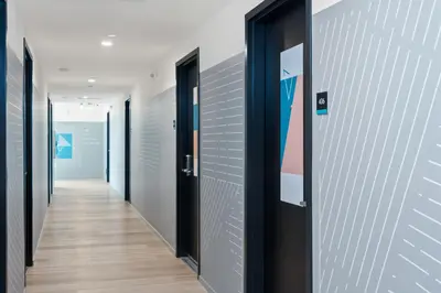 a hallway with black doors and wooden floors at The Metric - Los Angeles Downtown in Los Angeles