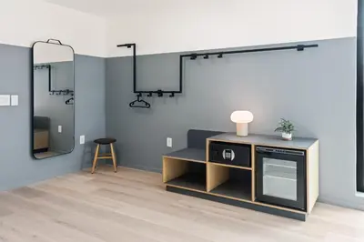 a room with a tv on a stand and a mirror at The Metric - Los Angeles Downtown in Los Angeles