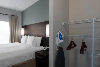a hotel room with a bed and a phone at Residence Inn by Marriott Lancaster Palmdale in Lancaster