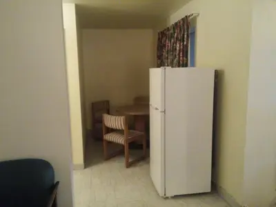 a kitchen with a white refrigerator and a table at Evergreen Inn in Covina
