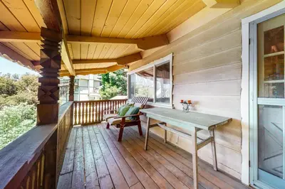 a wooden porch with a wooden table on a deck at Alpine Dream in Crestline