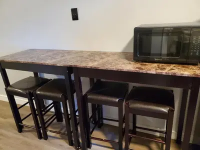 a counter with a microwave and some stools at Hotel Europa in Smeltzer