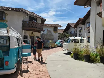 a man and a child walking down a street with cars at Hotel Europa in Smeltzer
