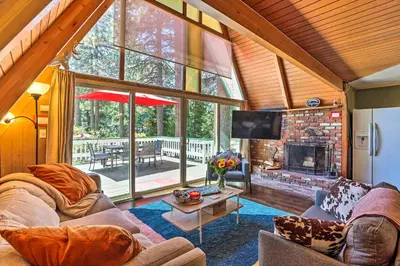 a living room with a couch and a fireplace at Running Springs A-Frame with Deck and Mtn Views! in Running Springs