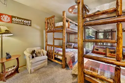 a bedroom with two bunk beds and a desk at Moose Manor #2012 by Big Bear Vacations in Big Bear Lake