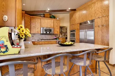 a kitchen with wooden cabinets and a island with bar stools at Moose Manor #2012 by Big Bear Vacations in Big Bear Lake