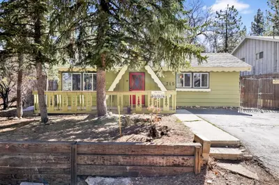 a yellow house with a fence in front of it at Marin Getaway #2013 by Big Bear Vacations in Big Bear Lake