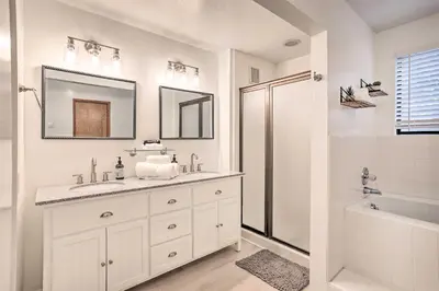 a white bathroom with a sink and a shower at Boho-Chic Home with Game Room Near Lake Gregory! in Crestline
