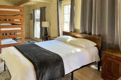 a bedroom with a bed with a wooden head board at Boho-Chic Home with Game Room Near Lake Gregory! in Crestline