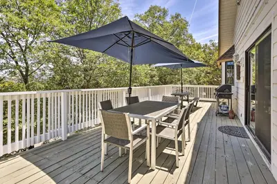 a table and chairs with an umbrella on a deck at Boho-Chic Home with Game Room Near Lake Gregory! in Crestline