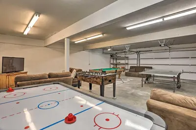 a living room with a ping pong table and couches at Boho-Chic Home with Game Room Near Lake Gregory! in Crestline