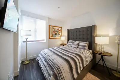 a bedroom with a bed with two lamps and a window at 4 SantaMonica De Lux in Los Angeles