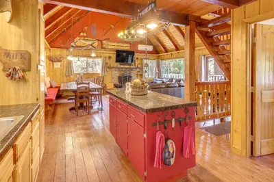 a kitchen and living room in a log cabin at Game Room and 2 Decks Walkable Lake Arrowhead Cabin in Lake Arrowhead