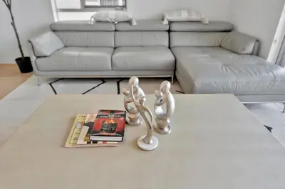 a living room with a coffee table with a book and a lamp at 3 Lux large apartment heart of SM in Los Angeles