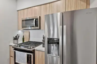 a kitchen with a stainless steel refrigerator and a microwave at 7 Large Down Town Santa Monica Apartment in Los Angeles