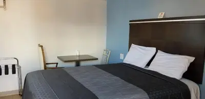a bedroom with a large bed and a table at DAY N NIGHT INN - Near Universal Studios Hollywood in Los Angeles