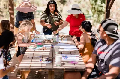 a group of people sitting around a picnic table at Huttopia Paradise Springs in Valyermo