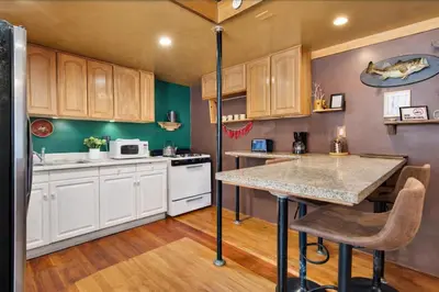 a kitchen with wooden cabinets and a counter top at St. Vincent Lofts in Los Angeles