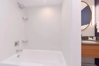 a white bathroom with a tub and a sink at Fairfield Inn and Suites by Marriott Bakersfield Central in Bakersfield