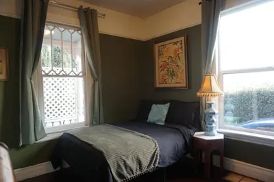 a bedroom with a bed and two windows at The Rosemary in Los Angeles