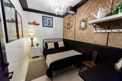a small bedroom with a bed and a chandelier at The Rosemary in Los Angeles