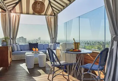 a balcony with a couch and chairs and a table at SIXTY Beverly Hills in Los Angeles