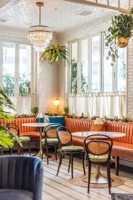 a restaurant with tables and chairs and windows at SIXTY Beverly Hills in Los Angeles