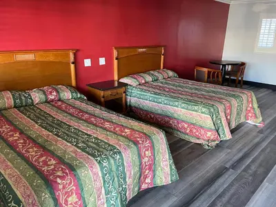 two beds in a hotel room with red walls at La Casa Motel, Garden Grove - Anaheim in Garden Grove