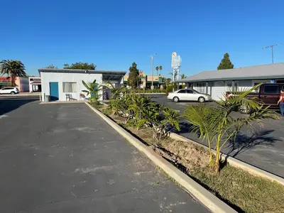 a parking lot with a car parked in a parking lot at La Casa Motel, Garden Grove - Anaheim in Garden Grove