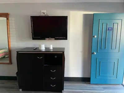 a room with a tv and a blue door at La Casa Motel, Garden Grove - Anaheim in Garden Grove