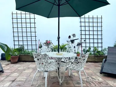 a table and chairs with an umbrella on a patio at Hollywood Hills Homestay in Los Angeles