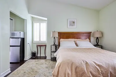 a bedroom with a large bed and a refrigerator at Hollywood Hills Homestay in Los Angeles