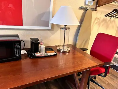 a table with a microwave and a lamp on it at Abby's Anaheimer Inn - Across Disneyland Park in Anaheim