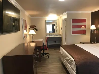 a hotel room with a bed and a desk at Abby's Anaheimer Inn - Across Disneyland Park in Anaheim