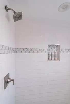 a white tiled shower with a shower head at 50 M to Sand LGB 2 King Suites in Long Beach