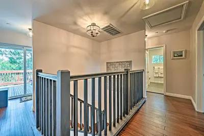 an empty hallway with a staircase in a house at Luxe Lake Arrowhead Farmhouse with Deck and Patio in Lake Arrowhead