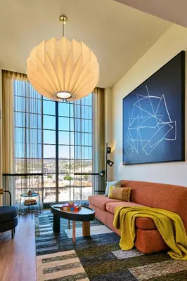 a living room with a couch and a large window at HOLLYWOOD VOLUME, a Tribute Portfolio Hotel in Los Angeles