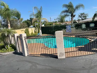 a gate in front of a swimming pool at Legacy inn & suites in Anaheim