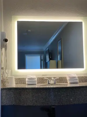 a bathroom sink with a large mirror above it at Legacy inn & suites in Anaheim