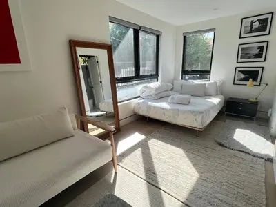 a living room with a couch and a mirror at Modern Bright New Studio with Roof-top Deck Walk to Santa Monica Beach, FreeWiFi, Parking in Santa Monica
