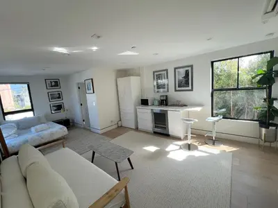 a living room with a couch and a table at Modern Bright New Studio with Roof-top Deck Walk to Santa Monica Beach, FreeWiFi, Parking in Santa Monica