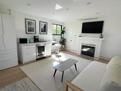 a living room with a fireplace and a tv at Modern Bright New Studio with Roof-top Deck Walk to Santa Monica Beach, FreeWiFi, Parking in Santa Monica
